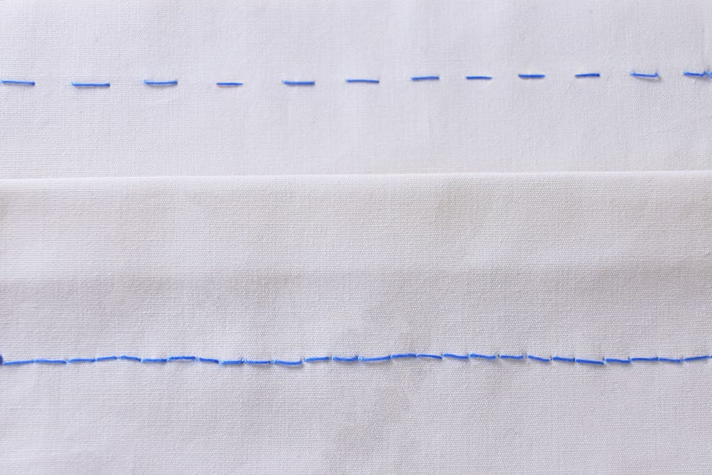 返し縫いと本返し縫いが青い糸で縫われた白い布